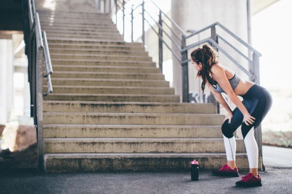 sporty woman looking at a big set of stairs